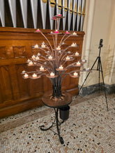 Steel prayer candle tree with candles lit at St. Luke's Church